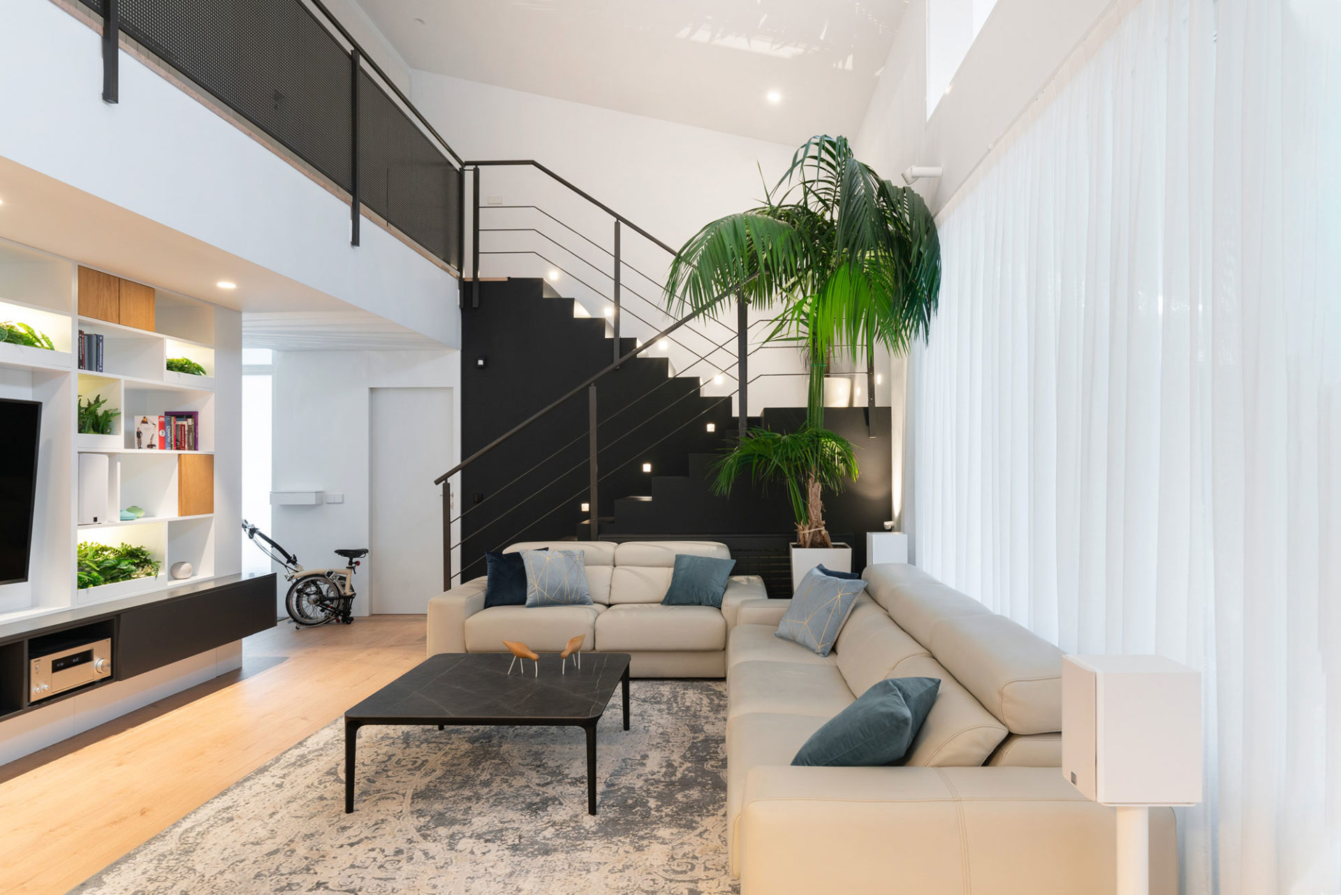 interiorismo salones con estilo modernos columen escalera en negro con mueble de diseño fabricado a medida